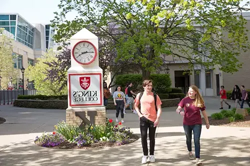 Students outdoors by a big clock
